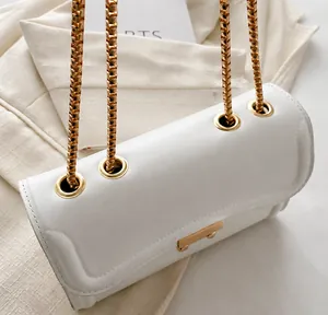 Close-up of white leather shoulder bag with gold chain strap and luxury metal connection
