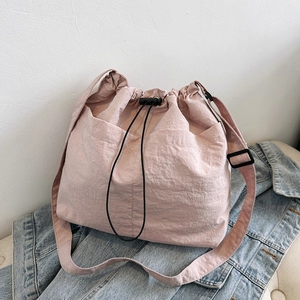Large casual light pink drawstring bucket tote bag with adjustable shoulder strap