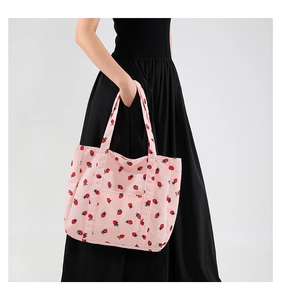 Dettaglio della borsa tote in velluto rosa con stampa di fragole e spalline robuste