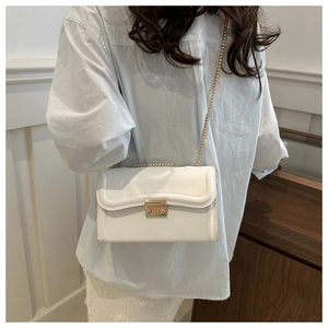 Vue détaillée d'un sac à bandoulière blanc minimaliste avec chaîne dorée et boucle