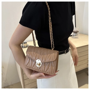 Détail du sac matelassé marron avec fermoir doré et bandoulière en chaîne chic