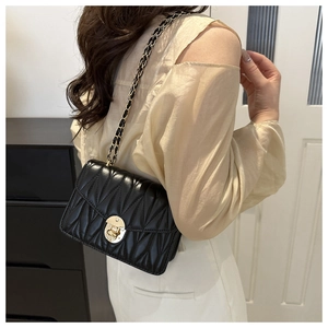 Détail du sac à bandoulière en cuir plissé noir avec chaîne dorée sur mannequin