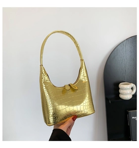 Gros plan sur le cuir doré à motif crocodile d'un sac hobo de style français