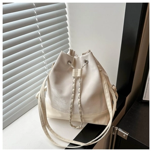 Nahaufnahme der elfenbeinfarbenen Beuteltasche mit Kordelzug und goldener Kette