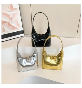Gros plan détaillé de trois sacs hobo à motif crocodile en argent, or et noir brillant