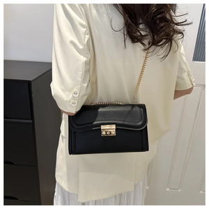 Détail du sac à bandoulière noir élégant avec chaîne dorée et fermoir en métal