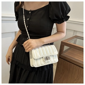 Détail du sac bandoulière blanc matelassé avec boucle argentée et bandoulière chaîne