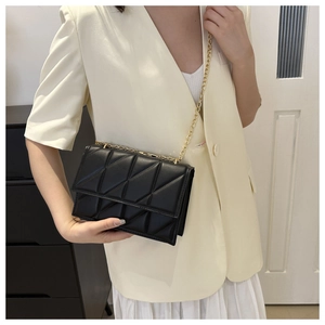 Detail of elegant black quilted leather shoulder bag with fine gold chain strap