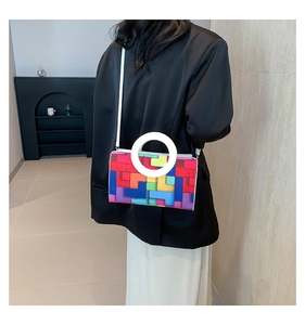 Détail du sac à main géométrique coloré avec poignée ronde blanche et bandoulière