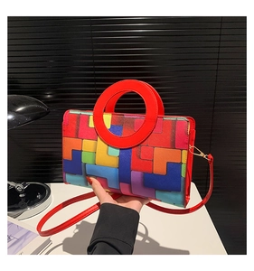 Détail des motifs géométriques colorés et des poignées rouges rondes du sac à bandoulière