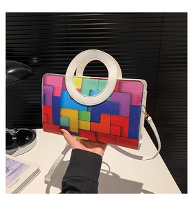Détail des motifs géométriques colorés et de la poignée ronde blanche d'un sac à main chic