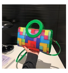 Détail du sac à main géométrique coloré avec poignées vertes rondes et bandoulière