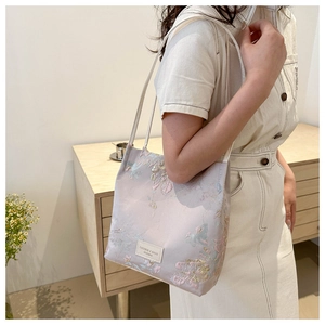 Détail de broderie florale et étiquette sur grand sac cabas lilas pour femme
