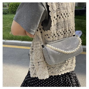 Détail du sac cylindrique en strass brillant avec poignée en perles et bandoulière chaîne