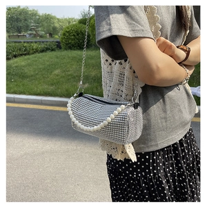 Détail du sac barillet argenté en strass avec poignée en perles et chaîne en métal