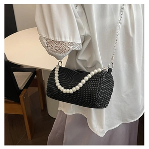 Detail of black rhinestone cylinder bag with pearl handle and silver chain strap
