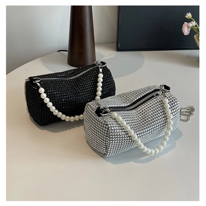 Detail of luxury rhinestone pillow bags with pearl handles and silver metal chains