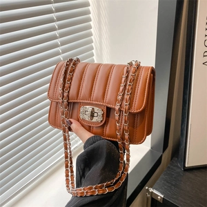 Sac bandoulière en cuir marron matelassé avec fermoir rotatif orné de strass brillants