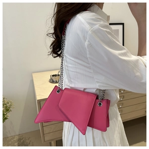 Detail of fuchsia geometric shoulder bag with metallic chain and asymmetric design