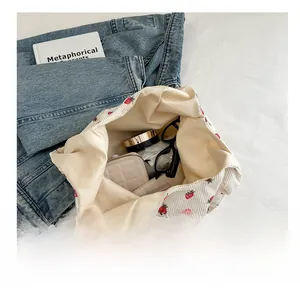 Grand sac cabas en velours côtelé à fraises montrant l'intérieur spacieux bien rempli