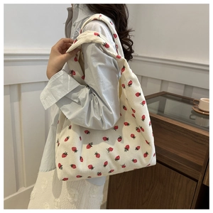 Détail de la texture du velours côtelé et de l'imprimé fraise sur le sac fourre-tout