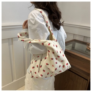 Détail du sac cabas en velours côtelé crème avec broderies fraises et texture douce