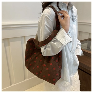 Détail du sac fourre-tout en velours côtelé marron foncé avec motif de fraises rouges