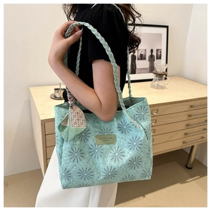 Detail view of mint green tote bag with daisy embroidery and braided handle for women