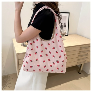 Détail de la broderie fraise sur un sac cabas en velours côtelé rose tendre