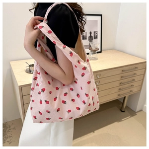 Sac fourre-tout en velours côtelé rose à motif fraises dans un décor chaleureux