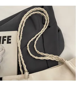 Gros plan détaillé du sac cabas crème montrant la texture de la bandoulière double tressée