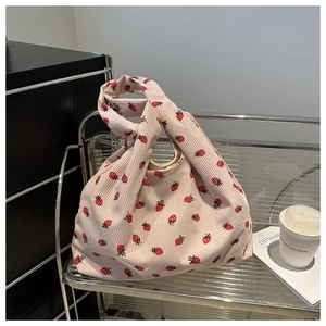 Détail du sac cabas en velours côtelé rose avec motif fraise et poignée nouée unique