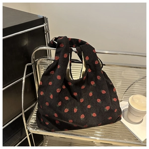 Détail du sac cabas en velours côtelé noir avec motifs fraises rouges et texture douce