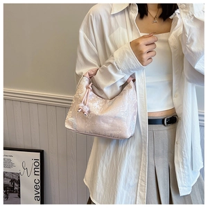 Detailed view of pink floral embroidery on a silk texture hobo bag with beaded drawstring