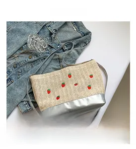 Sac à bandoulière en paille brodé de fraises rouges et anses en cuir argenté brillant