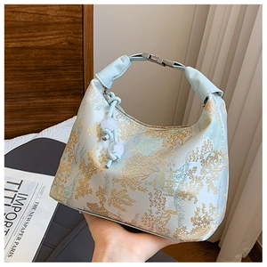Detail of light blue hobo bag with traditional Chinese mountain and floral embroidery
