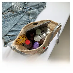 Détail du sac cabas tissé beige avec broderie fraise et grand compartiment intérieur