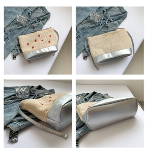 Vues détaillées du sac cabas en paille brodé de fraises avec bordure en cuir argenté