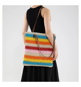 Detailed side view of large woven straw tote with colorful stripes and leather straps