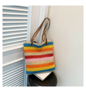 Detail of colorful rainbow woven tote bag with brown leather straps and zip closure