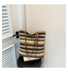 Detail of woven rainbow tote bag featuring black, beige, and brown striped crochet texture