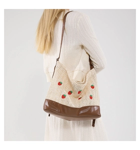 Détail du sac cabas en paille avec broderie fraise et bandoulière en cuir PU brun