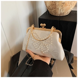 Detail of silk clutch bag with butterfly embroidery and heart-shaped pearl decoration