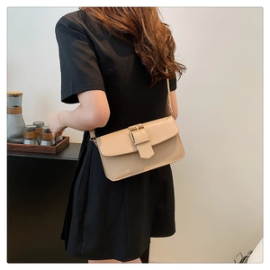 Détail d'un sac sous le bras rectangulaire beige avec boucle décorative sur mannequin