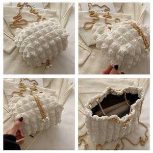 Detail of white bubble texture bucket bag with gold chain and pearl charms