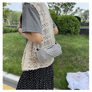 Détail du sac cylindrique en strass argenté avec chaîne métallique et texture chic