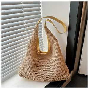 Detail of beige woven hobo bag with vibrant yellow leather strap and straw texture