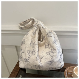 Close-up of textured butterfly jacquard fabric on a soft beige canvas tote bag