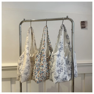 Detailed texture of butterfly pattern embroidery and floral fabric on tote bags