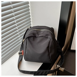Close-up of black Oxford cloth shell bag showing durable nylon texture and fashion tag